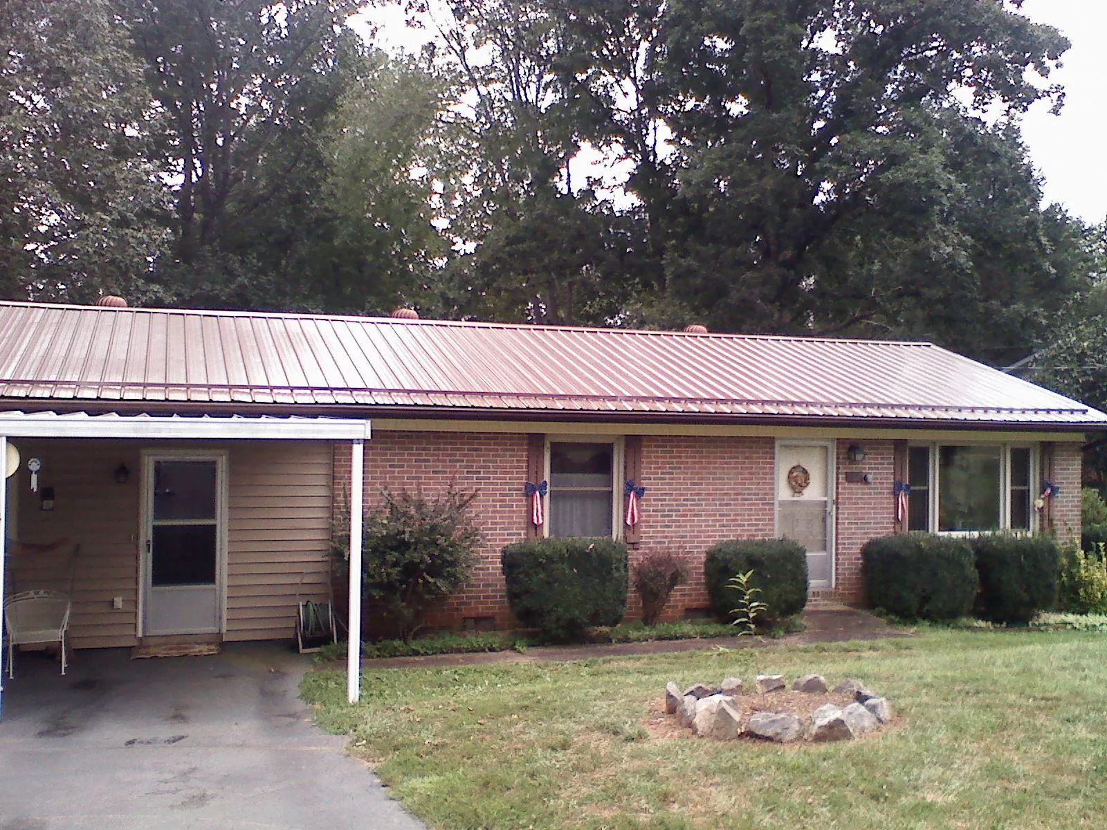 Bronze metal roof and carport on a brick ranch home — Roof Repair work by our crew in Foley